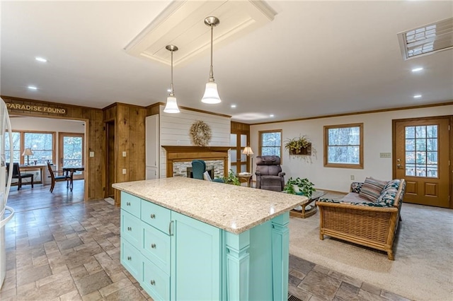 kitchen with open floor plan, a kitchen island, decorative light fixtures, and stone tile floors