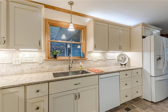 kitchen with light stone countertops, white appliances, a sink, decorative backsplash, and decorative light fixtures