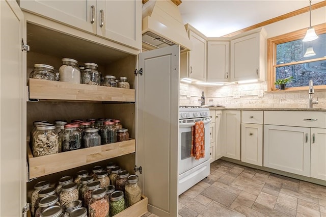 kitchen with decorative light fixtures, gas range gas stove, tasteful backsplash, custom range hood, and stone finish flooring