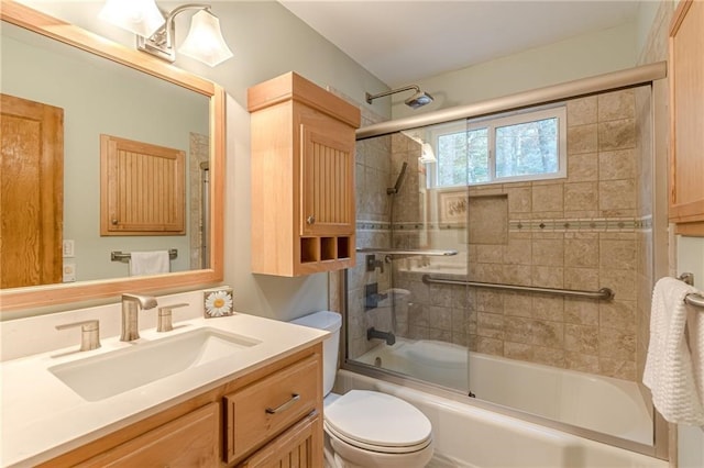 bathroom with toilet, bath / shower combo with glass door, and vanity