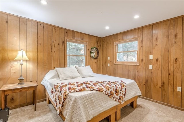 bedroom with baseboards, multiple windows, and light colored carpet