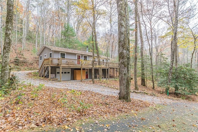 view of front of home featuring a garage, driveway, stairway, and a wooden deck