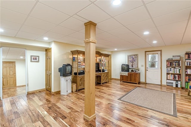 interior space featuring a paneled ceiling, recessed lighting, light wood-style flooring, and baseboards