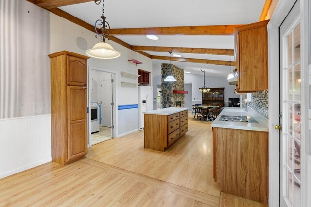 59 Tusquittee Creek Ln, Hayesville, NC 28904 - kitchen featuring white fridge with ice dispenser, a kitchen island, washer / dryer, light wood-style flooring, and wainscoting