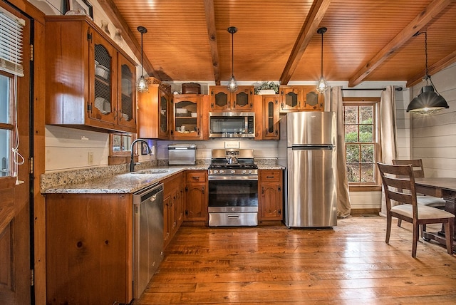 kitchen featuring decorative light fixtures, dark hardwood / wood-style flooring, light stone countertops, and appliances with stainless steel finishes