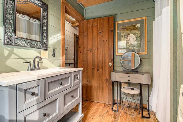 bathroom with wooden walls, vanity, and wood-type flooring