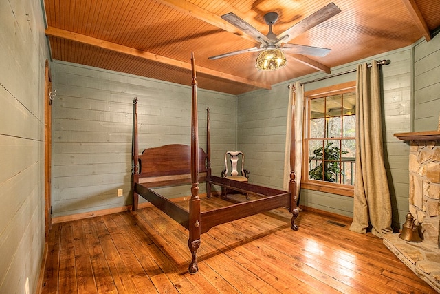 bedroom with wood walls, ceiling fan, wood ceiling, and light wood-type flooring