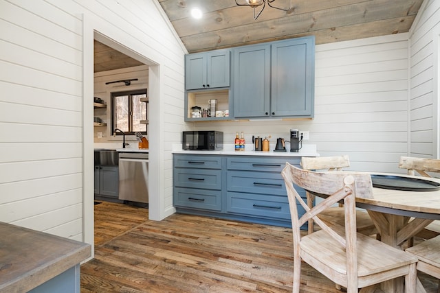 interior space featuring dishwasher, blue cabinetry, vaulted ceiling, and dark hardwood / wood-style floors