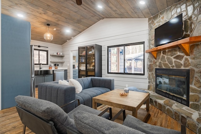 living room featuring plenty of natural light, wood-type flooring, wooden walls, and wood ceiling