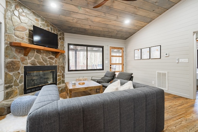 living room with wooden ceiling, a fireplace, lofted ceiling, wooden walls, and light wood-type flooring