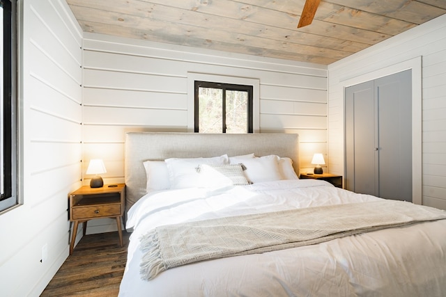 bedroom with wood walls, dark hardwood / wood-style floors, ceiling fan, and wooden ceiling