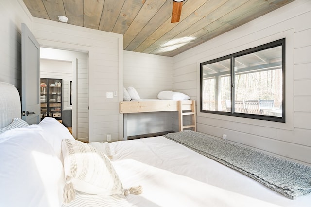 bedroom featuring wood walls, ceiling fan, and wood ceiling