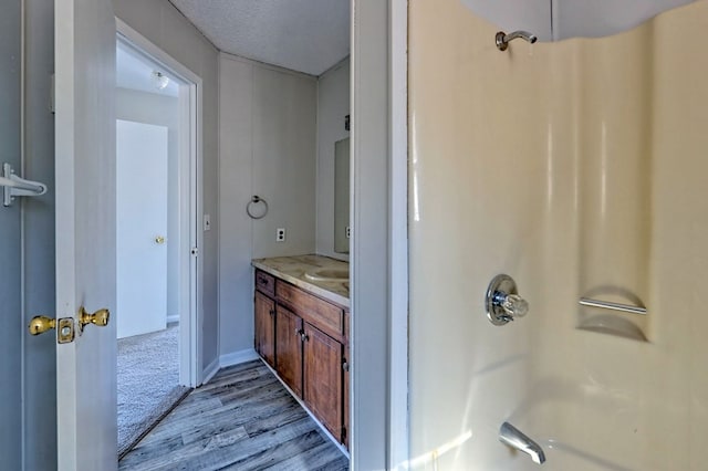 bathroom featuring a shower, hardwood / wood-style floors, vanity, and a textured ceiling