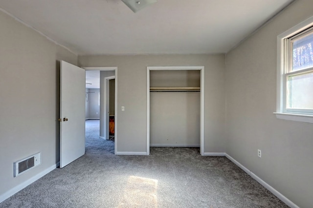 unfurnished bedroom with light carpet and a closet