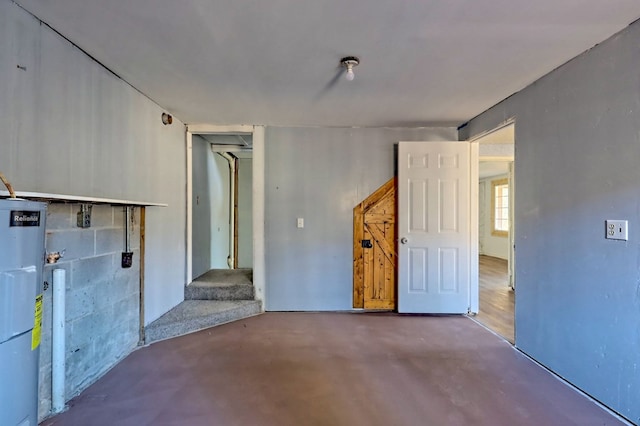 empty room featuring concrete flooring and water heater