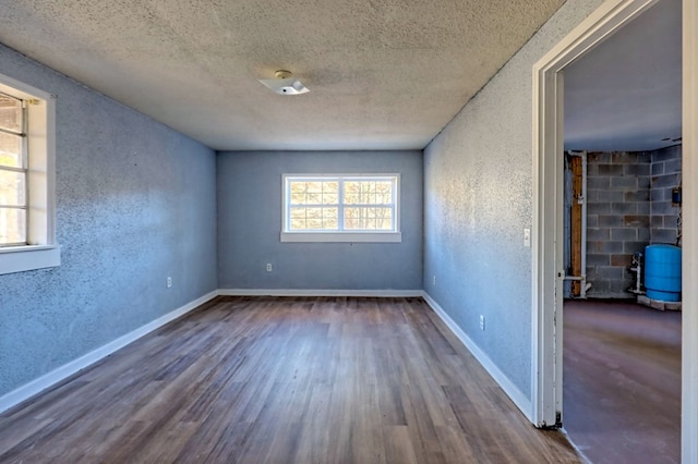 empty room featuring wood-type flooring and a textured ceiling