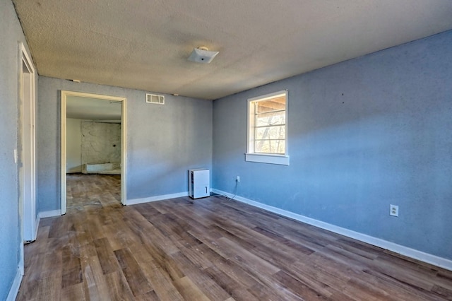 spare room with hardwood / wood-style floors and a textured ceiling