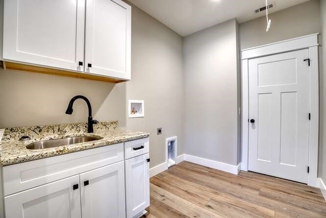 laundry area featuring hookup for an electric dryer, hookup for a washing machine, light wood-type flooring, cabinets, and sink