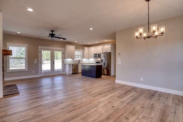 kitchen featuring hanging light fixtures, a kitchen island, appliances with stainless steel finishes, light hardwood / wood-style floors, and white cabinetry