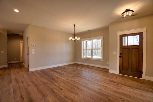 entryway with an inviting chandelier and hardwood / wood-style flooring