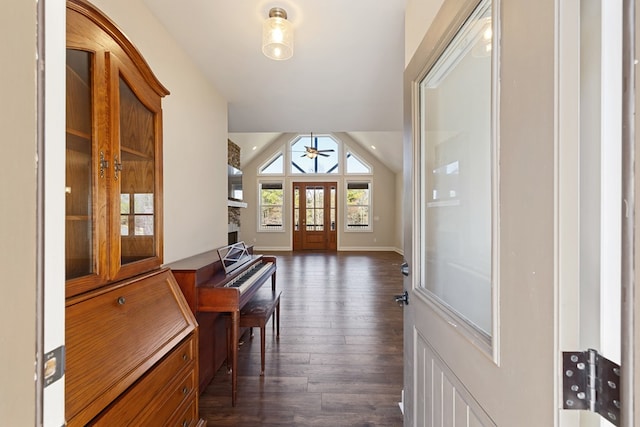 foyer with baseboards, lofted ceiling, dark wood-style floors, and a ceiling fan