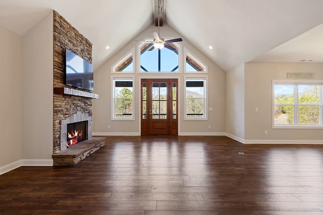 unfurnished living room with dark wood finished floors, a fireplace, and a wealth of natural light