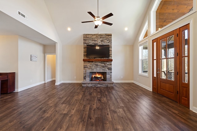 unfurnished living room featuring visible vents, dark wood-type flooring, baseboards, a fireplace, and a ceiling fan