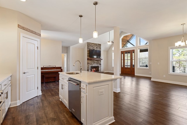 kitchen featuring a sink, dark wood finished floors, open floor plan, a fireplace, and stainless steel dishwasher