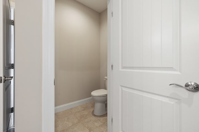 bathroom with toilet and baseboards