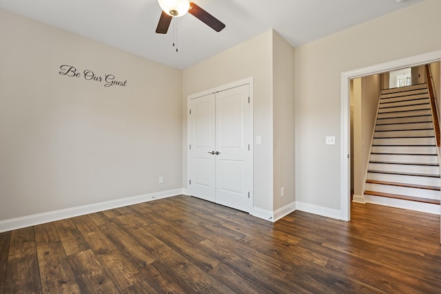 unfurnished bedroom featuring a closet, baseboards, dark wood-style floors, and a ceiling fan