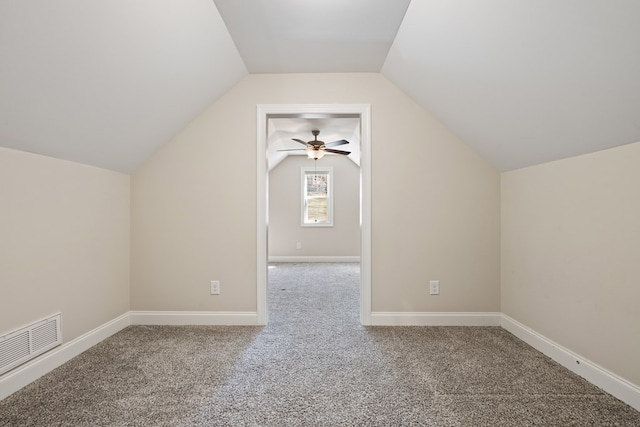 additional living space with visible vents, baseboards, carpet, and vaulted ceiling