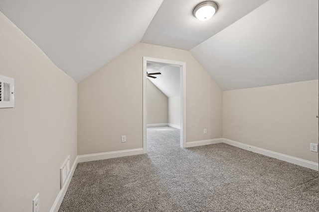 additional living space with visible vents, carpet floors, baseboards, and vaulted ceiling