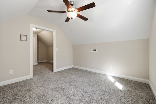 additional living space with vaulted ceiling, carpet flooring, baseboards, and visible vents