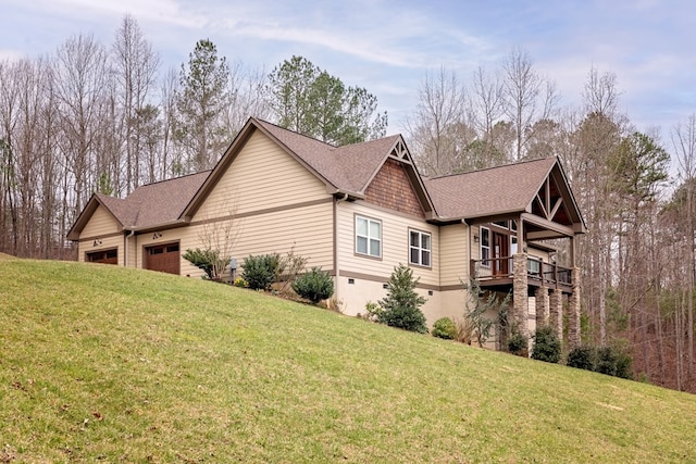 view of property exterior with an attached garage, a yard, and a shingled roof