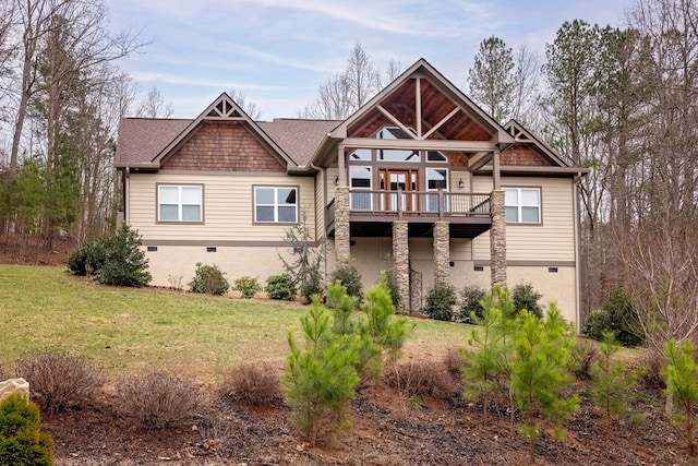 rear view of property with a shingled roof, a balcony, a yard, and crawl space