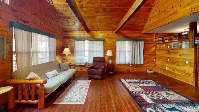 living area with lofted ceiling with beams, wooden walls, and a wealth of natural light