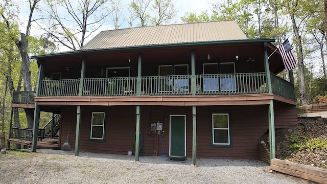 view of front of home with stairway, a wooden deck, and metal roof
