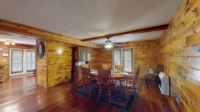 dining room featuring wooden walls, heating unit, beamed ceiling, and hardwood / wood-style flooring