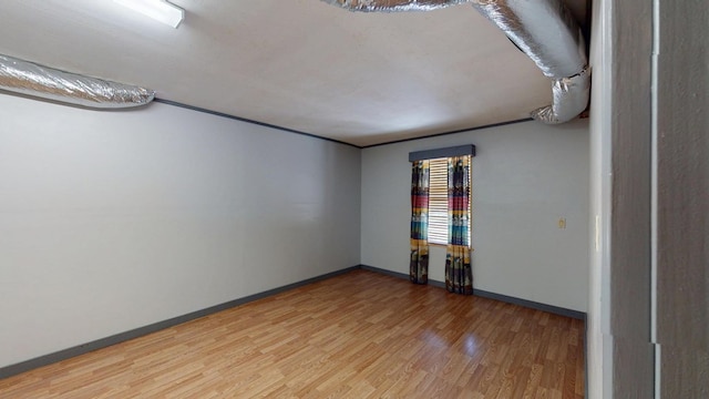 empty room with baseboards and light wood-type flooring