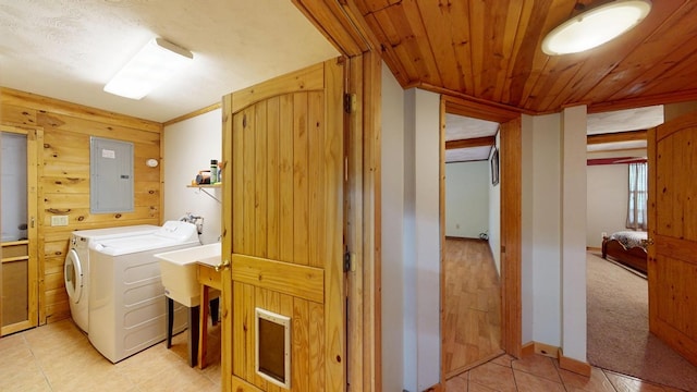 washroom featuring laundry area, electric panel, light tile patterned floors, wooden ceiling, and separate washer and dryer