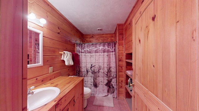 full bathroom with a shower with curtain, wood walls, tile patterned flooring, and vanity