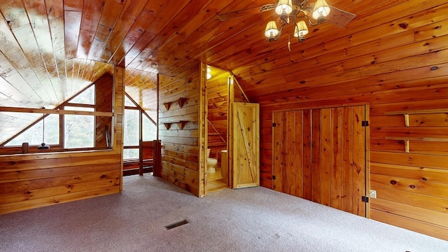 bonus room featuring ceiling fan, wood walls, wooden ceiling, lofted ceiling, and carpet