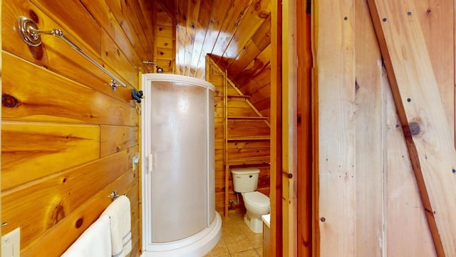 bathroom featuring wooden walls, tile patterned flooring, toilet, a shower stall, and lofted ceiling
