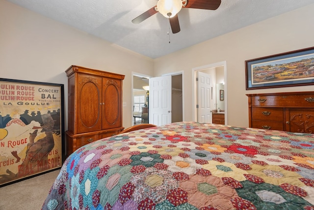 carpeted bedroom featuring a textured ceiling, ceiling fan, and connected bathroom