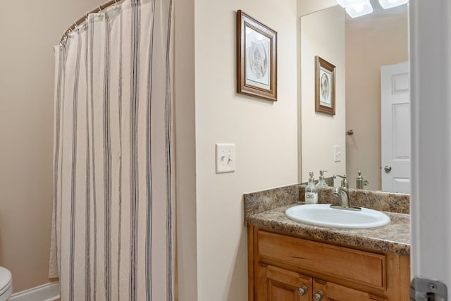 bathroom featuring toilet, vanity, and walk in shower