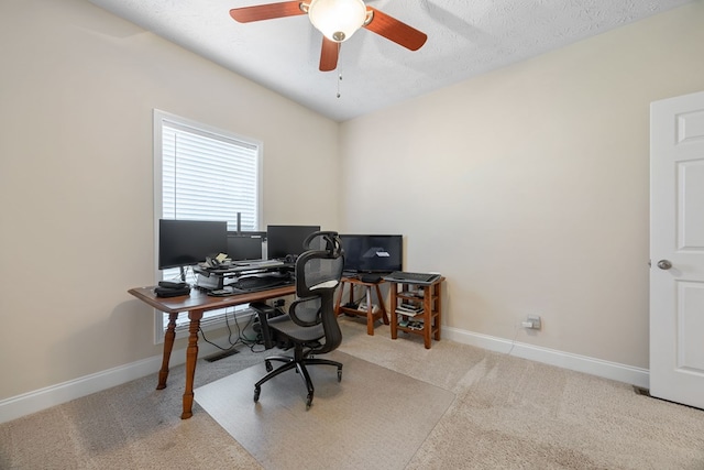 carpeted office space with ceiling fan and a textured ceiling