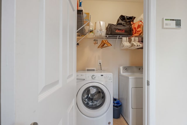 clothes washing area featuring light tile patterned flooring and washing machine and clothes dryer