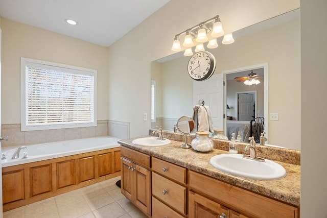 bathroom featuring ceiling fan, a tub to relax in, tile patterned flooring, and vanity