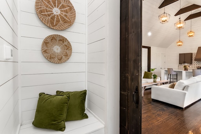 interior space featuring wooden walls, vaulted ceiling, and wood finished floors