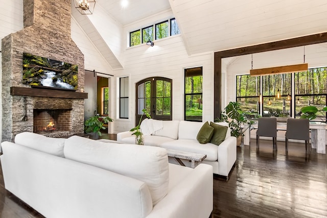 living room featuring dark wood finished floors, a fireplace, and high vaulted ceiling